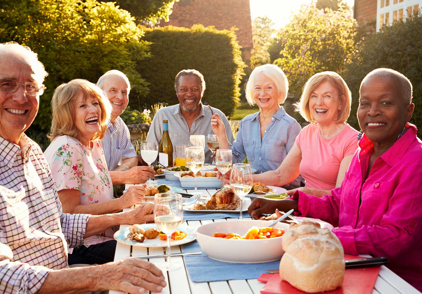 senior friends enjoying dinner outdoors