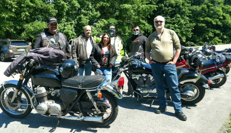 Fabian Bedne and group of people standing next to motorcycles