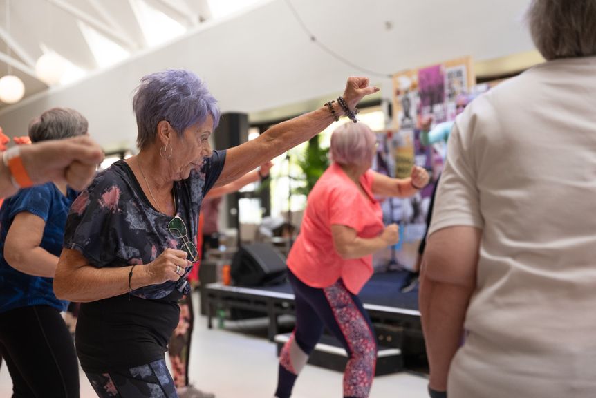 Group of senior women engaged in fitness activities indoors, promoting healthy aging.