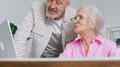 A senior couple enjoying time together while using a laptop, showcasing love and technology.